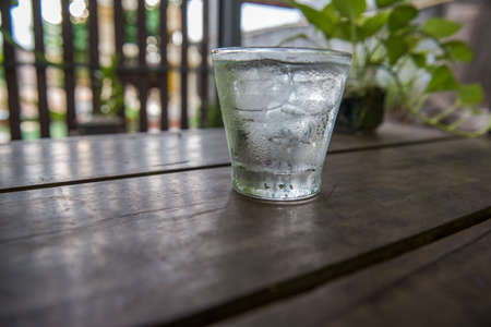 Cold water in a glass on a wooden table.の写真素材