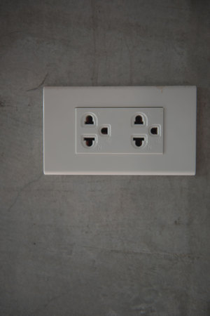 White plug on gray wall , for background.