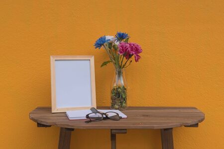 photo Frame on a wooden table and Yellow background .の写真素材