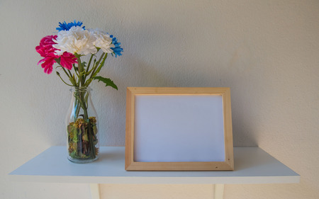 photo Frame on a wooden and Flowers in jar on White background .の写真素材