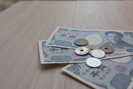 Closeup coin yen and banknotes Japanese  on wooden background. Currency of Japan.の写真素材