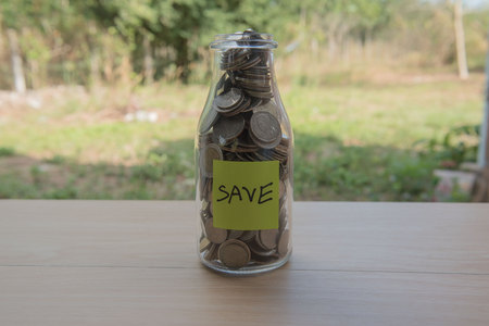 âSaveâ Writing in the paper, Coins in a glass jar, concept Saving Money  step with deposit coin in bank stack growing business.の写真素材