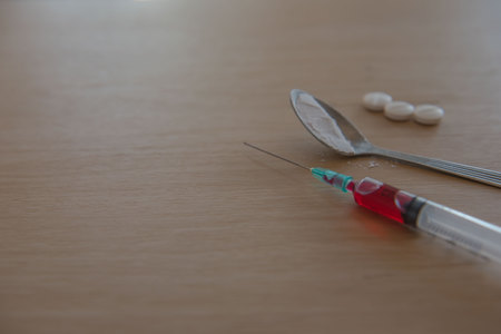 syringe and blood, Drug and  spoon cooked heroin on a wooden background. in the studio.の写真素材