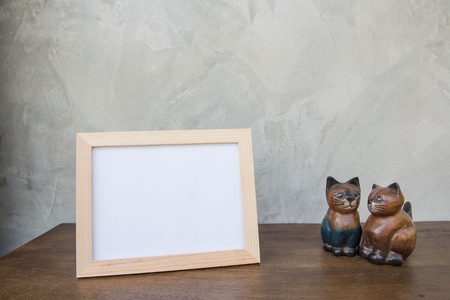 photo Frame and toy cat on a wooden on Gray wall background .の写真素材