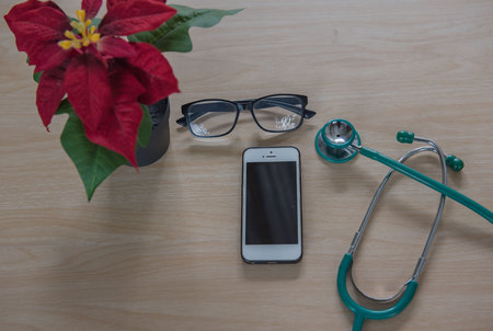 Top view stethoscope Medical equipment and phone on wooden background. Doctor workplace in office .の写真素材