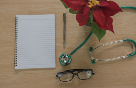 Top view stethoscope Medical equipment and book on wooden background. Doctor workplace in office .の写真素材