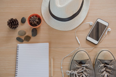 Top view Concept travel accessories. Hat, book, phone, shoes, Earphone on wooden background.の写真素材