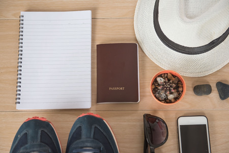 Top view Concept travel accessories. Hat, book, phone, shoes, passport, sunglasses,  on wooden background.の写真素材
