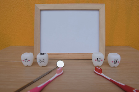 photo Frame and Model toys teeth in dentistry on a wooden on Yellow background . Concept for health.の写真素材