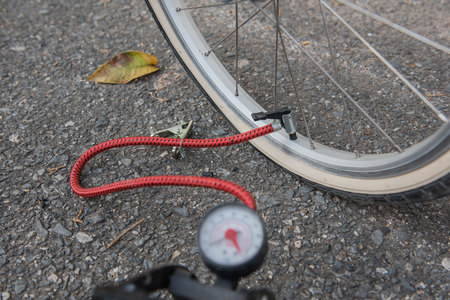 Air pump at the wheel rubber bicycle. Bike tires have problems.の写真素材