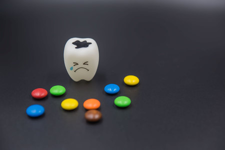 Model Cute toys teeth and colorful candy in dentistry on a black background.の写真素材
