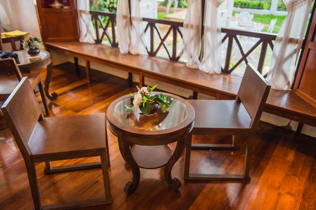 Wooden table and chair and white curtains background .の写真素材