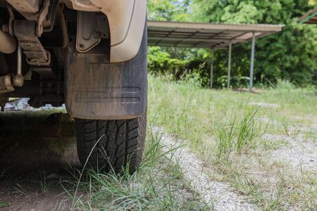 The back tire of cars parked on grass.の写真素材