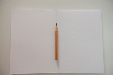 Pencils on the white book on the table .の写真素材