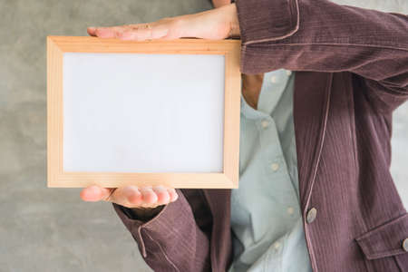 Blank wooden photo Frame in the woman's hand .の写真素材