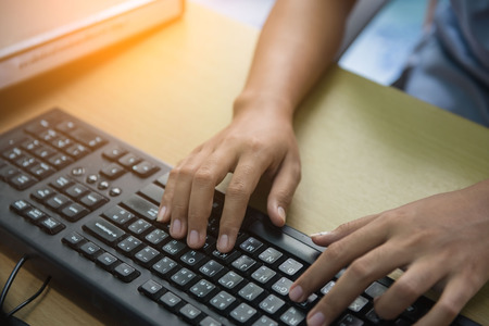 Woman hand typing on the keyboard working in office. Business concept.