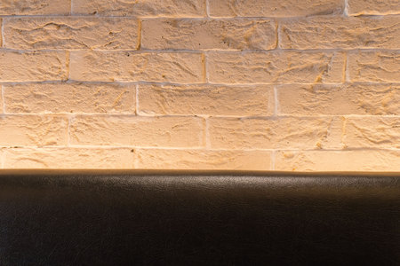 Orange Brick wall and leather black sofa  for wallpaper.  surface, texture .の写真素材