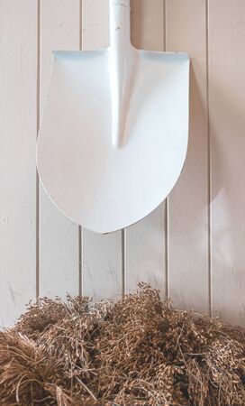 White shovel hanging on a white wooden wall .の写真素材