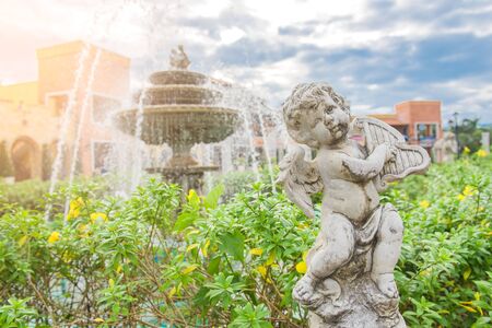 Cute little child sculpture decorate in front of fountain in the garden .の写真素材