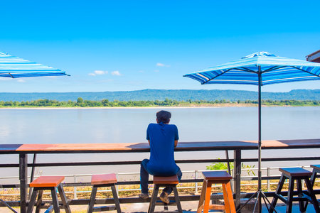 man alone sit on the balcony alone near riverside .の写真素材
