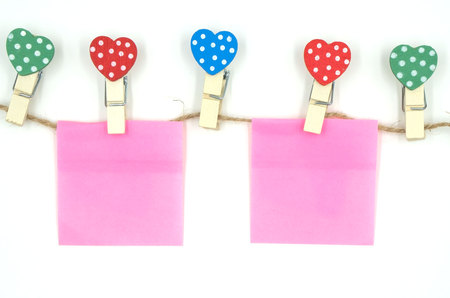 colorful clothespin with heart shape design and pink  paper sheet and rope for valentine concept isolated on white background . Space for text and images .の写真素材