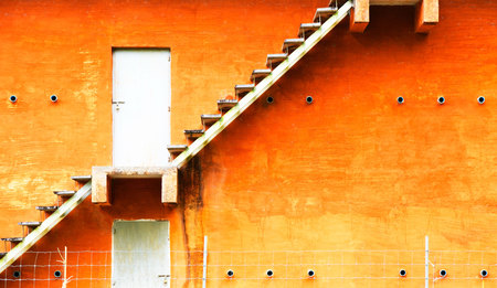 Orange building and Fire escape stairs on the outside .