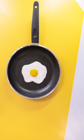 black pan and Fried egg on yellow and white background .の写真素材