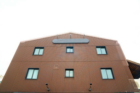 Brown Building with windows and sky background .