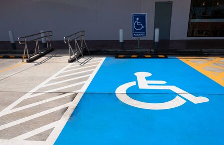 traffic sign about handicapped symbol painted in bright blue . Disabled parking spaces .の写真素材