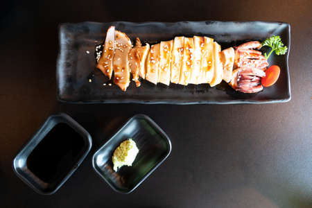 grilled squid with teriyaki sauce on black plate . Japanese seafoodÂ .の写真素材