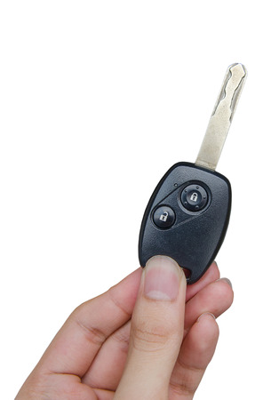 Hand holding car keys isolated on white backgroundの写真素材
