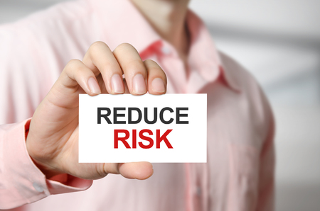 Reduce Risk text on the card in hand man.の写真素材