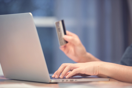 Woman hands holding credit card while using laptop. Online shopping concept.の写真素材