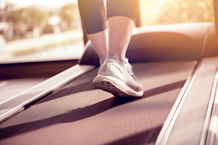 Woman running in machine treadmill at fitness gym at morning.の写真素材
