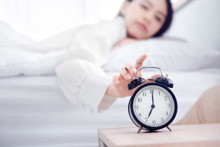 Close-up Hand turns off the alarm clock waking up at morning.の写真素材