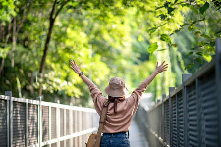 Happy woman spreading her arms in the Nature trail, Active outdoor relax in nature.の写真素材