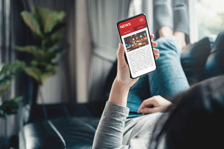 Online news on a smartphone. Mockup website. Woman reading news or articles in a mobile phone screen...