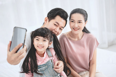 Closeup - Happy asian family taking selfie at home.の写真素材