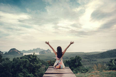 Freedom traveler woman relaxing with raised arms on the top of mountain at Samed nang chee Thailand, Enjoy travel concept.の写真素材