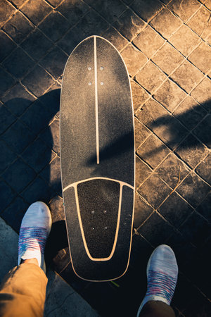 Closeup feet of man in sneakers and surf skate or skateboard on the road, Sport activity lifestyle concept, Healthy and exercise.の写真素材