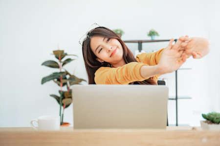 Happy relaxed young woman sitting after using laptop.