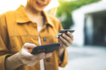 Hands of woman holding using mobile phone and credit card, Online shopping Website, Shop online by...
