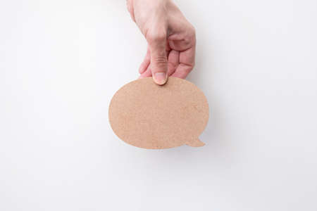 Woman hand holding bubble talk notification isolated over white background.