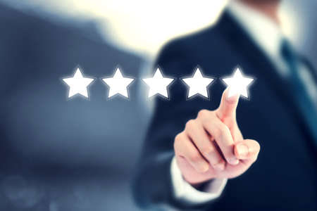 Increase rating or ranking, Businessman click on five stars to increase rating of his company. evaluation and classification concept.の写真素材