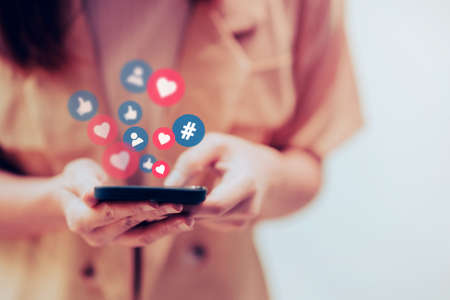 Hands of woman using a social media marketing concept on mobile smartphone with notification icons.