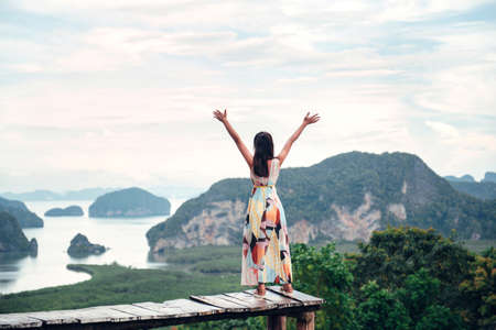 Freedom traveler woman relaxing with raised arms on the top of mountain at Thailand, Enjoy travel concept.の写真素材