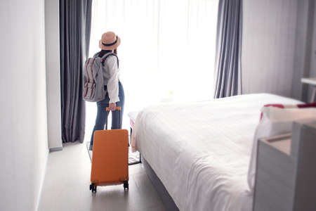 Tourist woman with luggage in hotel after check-in. Conceptual of travel and vacation.の写真素材