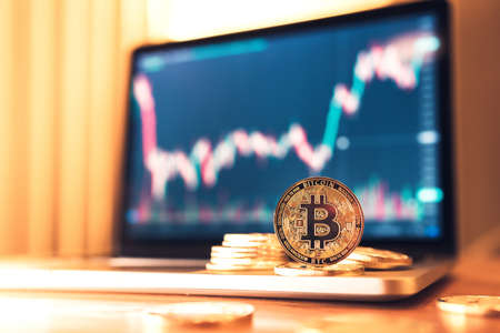 Close up - Cryptocurrency Gold Bitcoin BTC on the candlestick chart on laptop background. copy space.の写真素材