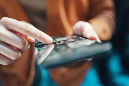 Online movie stream with smartphone. Woman watching film on mobile phone with imaginary video player service.の写真素材