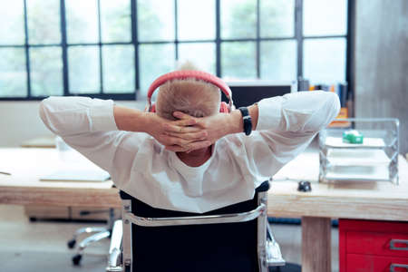 Happy relaxed young man sitting after using laptopの写真素材